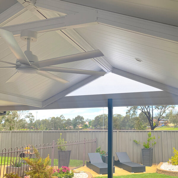 DIY attached gable roof patio with ceiling fan and garden space.