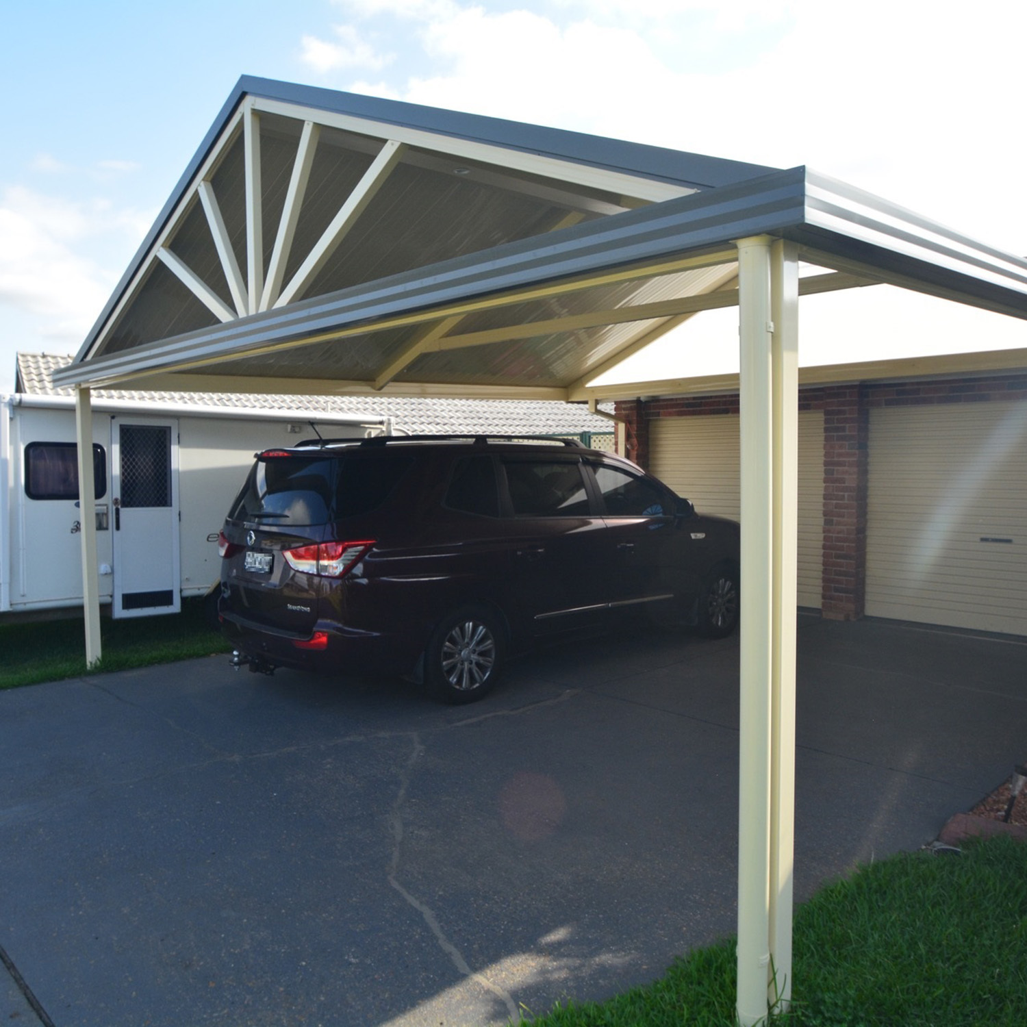 Black SUV parked under a metal DIY freestanding gable roof carport